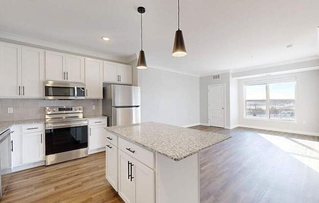 A kitchen with white cabinets and a granite countertop.