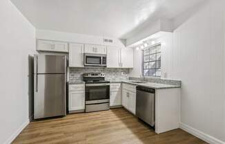 A kitchen with white cabinets and stainless steel appliances.