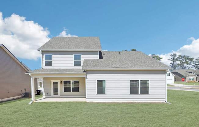 A two-story house with a grey roof and white siding.