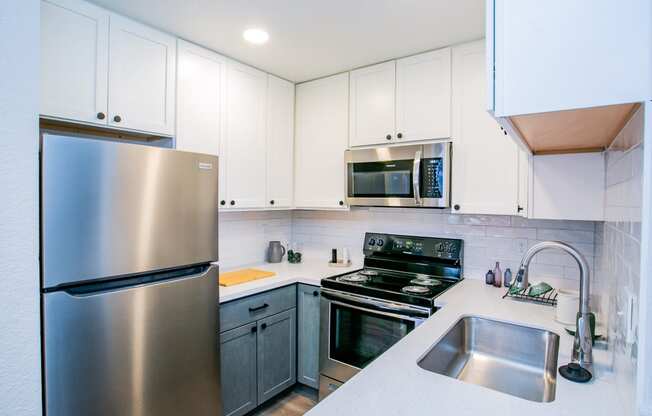 a kitchen with stainless steel appliances and white cabinets