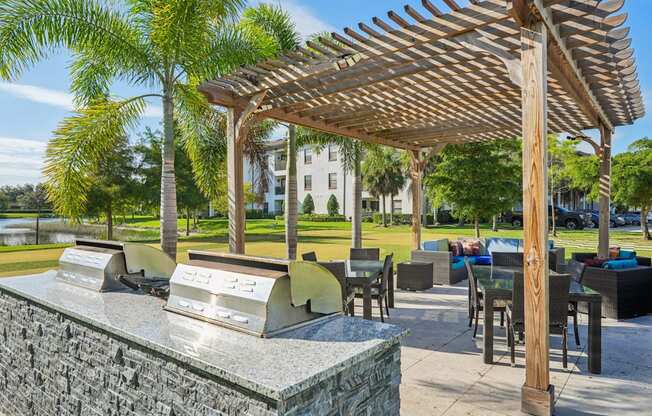 A wooden pergola is over a table with chairs.