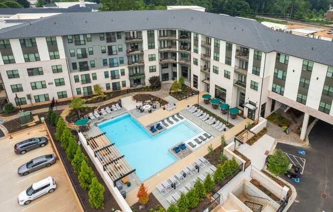 an aerial view of a large swimming pool in front of a building