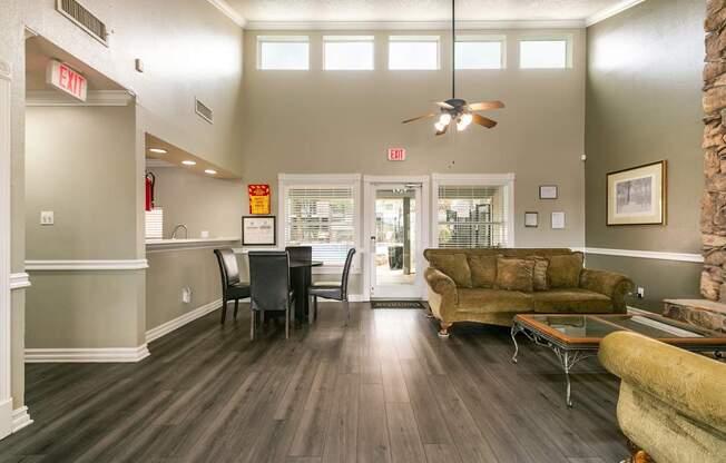 A living room with a brown couch and a dining table.