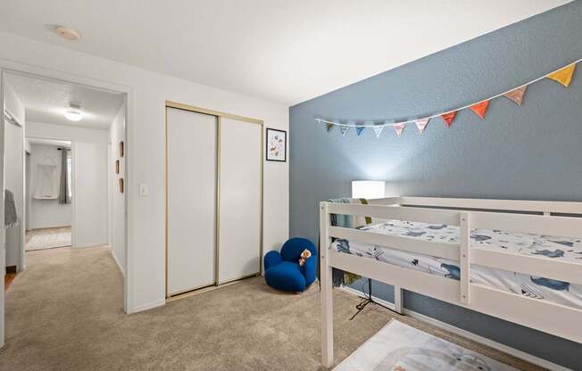 A room with a bed, a chair, and a wall clock at Clackamas Trails Apartments, Oregon, 97222