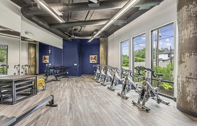 Fitness room featuring spin bikes and a variety of free weights at Allusion at West University apartments in Houston, TX