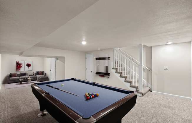 a basement with a pool table and a staircase