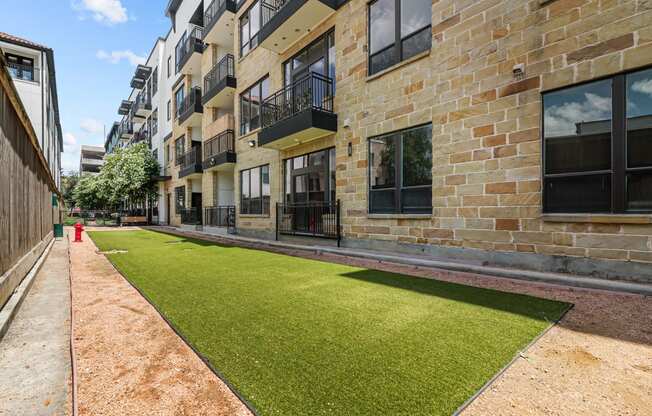 an apartment building with a green lawn in front of it