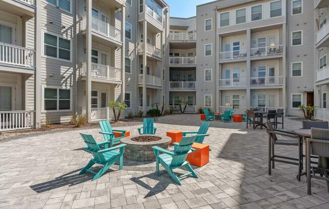 an outdoor patio with chairs and tables in an apartment building