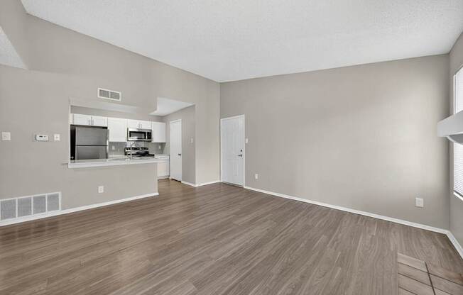 A room with a wooden floor and a wall-mounted television.