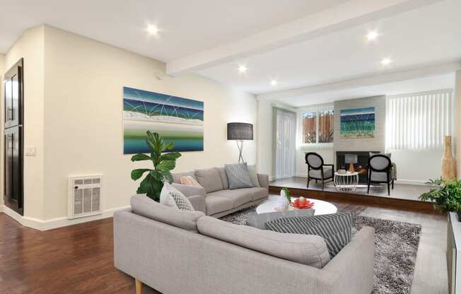 Living room with cozy fireplace, recessed lighting, wood style flooring. Not all features are available in every apartment.