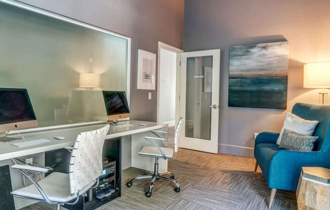 A modern home office with a desk, chair, and a painting on the wall.
