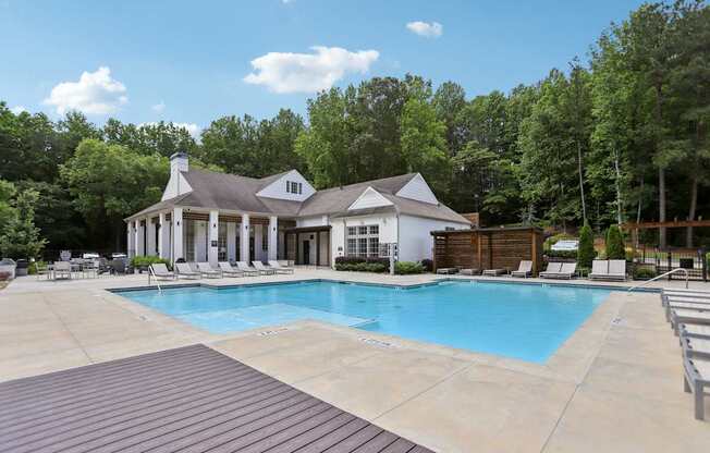 A pool with a cabana and many suntan and lounge chairs