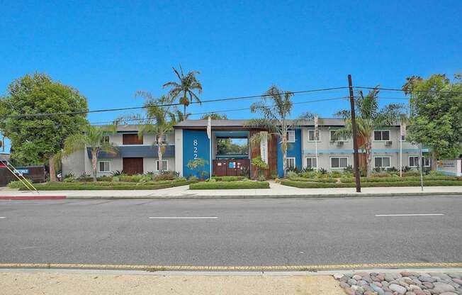 A street view of a residential area with houses and a clear blue sky.