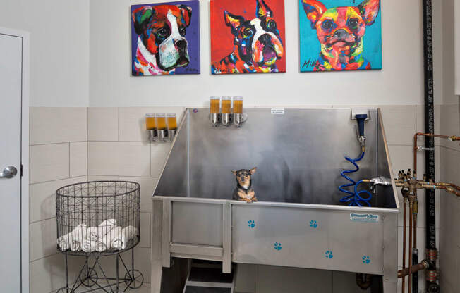 a dog sitting on a table in front of a painting of a dog