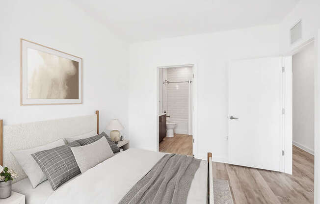 Model Bedroom with Wood-Style Flooring and attached Bathroom at Stella Apartments located in New Carrollton, MD.