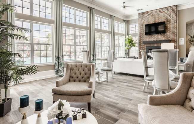 a living room with large windows and a table with chairs