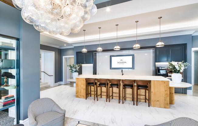 Dual-purpose coworking lounge and demonstration kitchen with bar seating, and sculptural lighting designed for a focused work retreat.