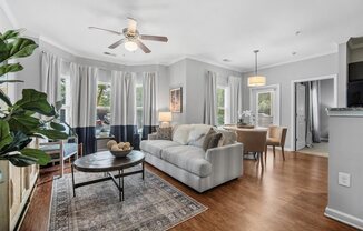 A living room with a couch, coffee table, and a ceiling fan.