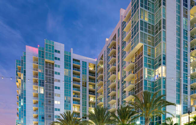 a view of a tall building at night with palm trees  at Vue, San Pedro, CA, 90731