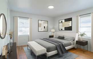 a bedroom with a bed and two windows at Ann Street Lofts, Alabama