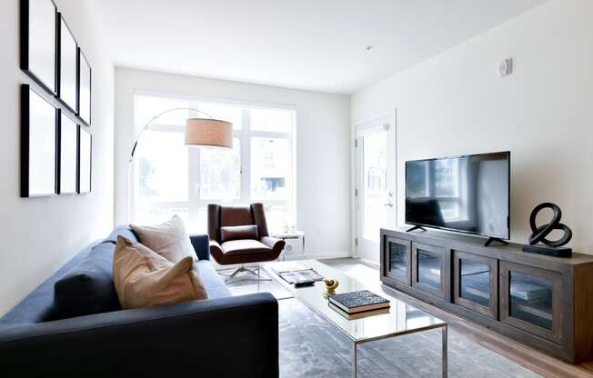 a living room with a black couch and a television