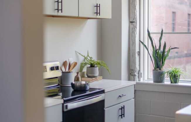 a kitchen with white cabinets and a window at The 22 Apartments, St. Louis, MO