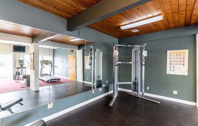 A gym with a green wall and a wooden ceiling.