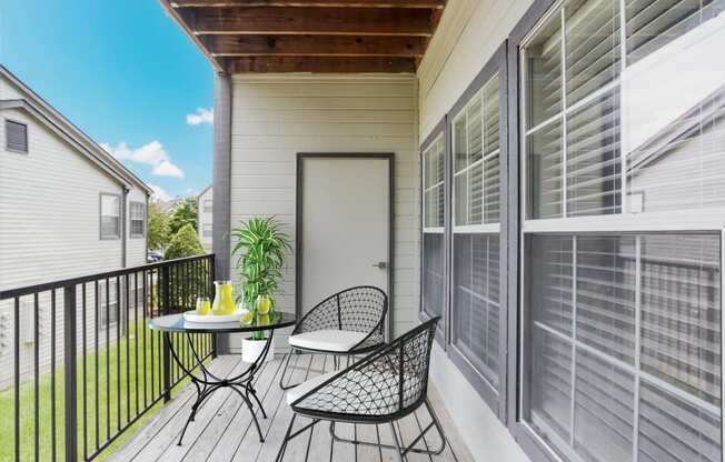 a balcony with a table and chairs and a door