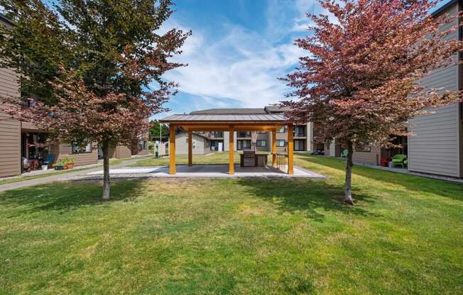 a covered area in the middle of a grassy area with trees on either side at Brix, Washington, 99362