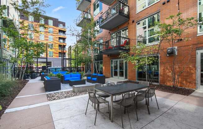 an outdoor patio with tables and chairs in front of a building