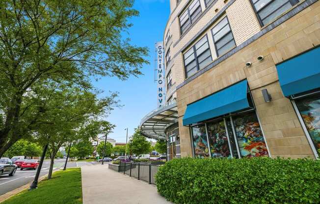 A sidewalk runs alongside a building with a blue awning.