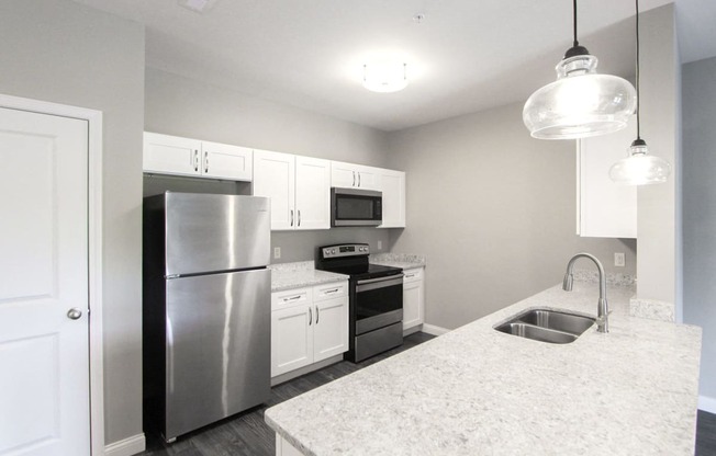 a kitchen with white cabinets and stainless steel appliances