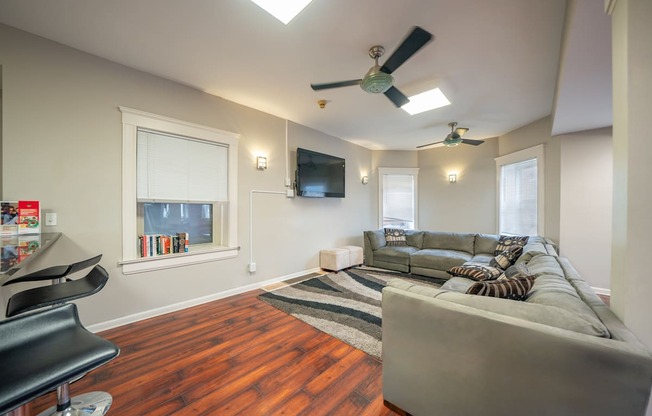 Clubhouse with a grey couch and breakfast bar area.