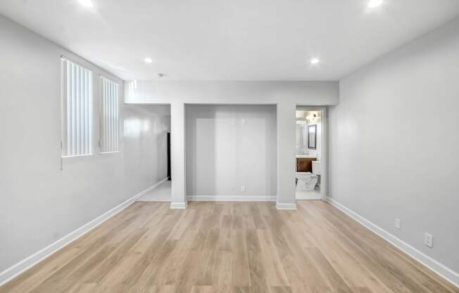 a renovated living room with white walls and wood flooring