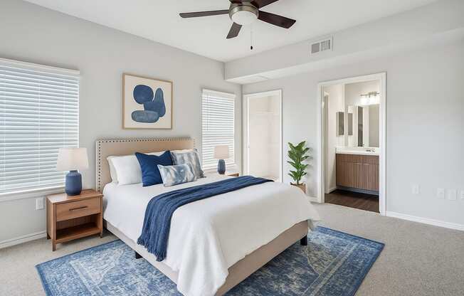 A bedroom with a bed, a ceiling fan, and a rug.