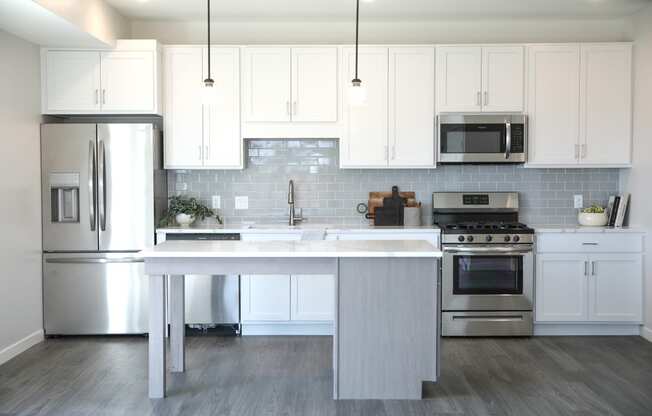 a kitchen with white cabinets and stainless steel appliances