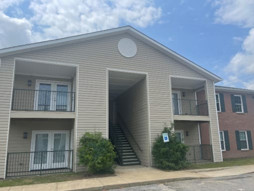 the front of an apartment building with stairs and balconies