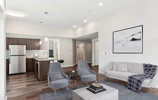Model Living Room with Wood-Style Flooring and View of Kitchen at Seven Skies Apartments located in Sandy, UT.