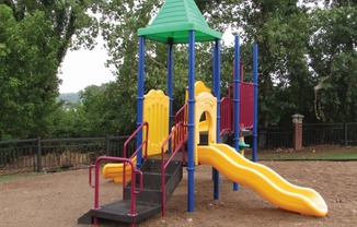 a playground with a yellow slide and a red and blue slide at GABLE HILLS Apartments, Oklahoma