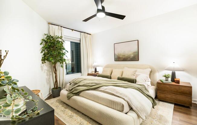 A light-filled bedroom at Modera Nations features wide-plank flooring and a calming layout, with Downtown Nashville just moments from home.