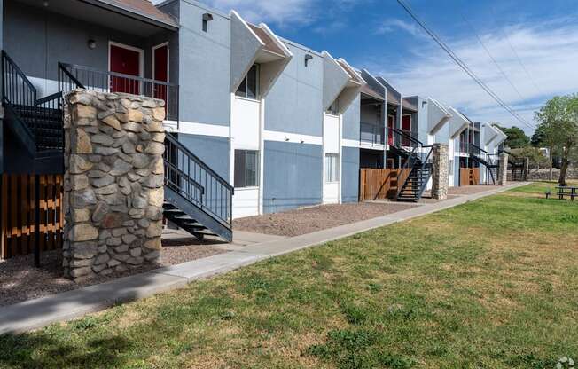A row of modern townhouses with a stone pillar in front of the first one.