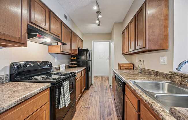 A kitchen with wooden cabinets and a black stove top oven.