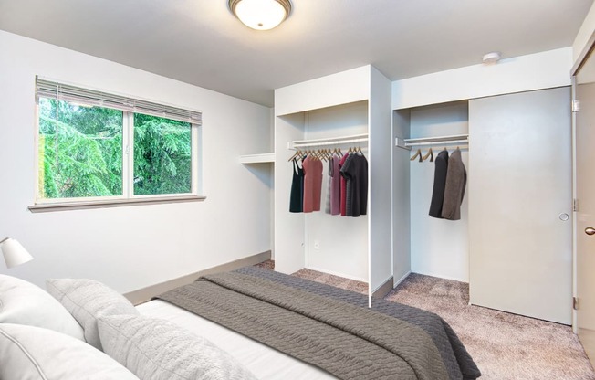 a bedroom with a bed and a closet with a window