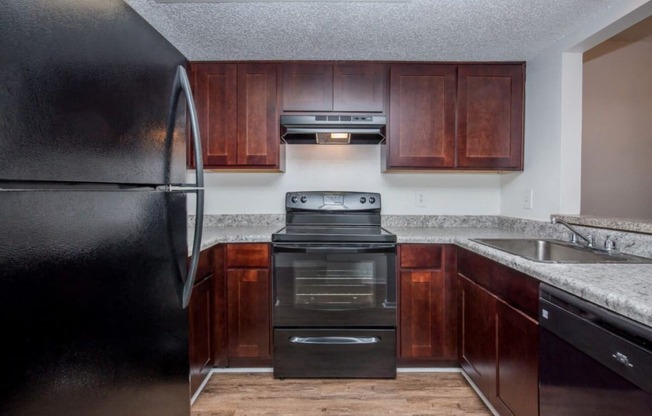 a close up of a kitchen with wood cabinets