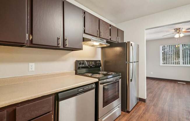 A kitchen with dark brown cabinets and stainless steel appliances.