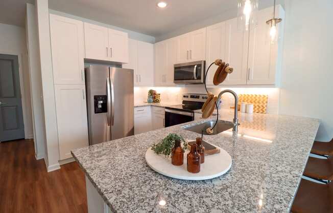 a kitchen with white cabinets and a granite counter top