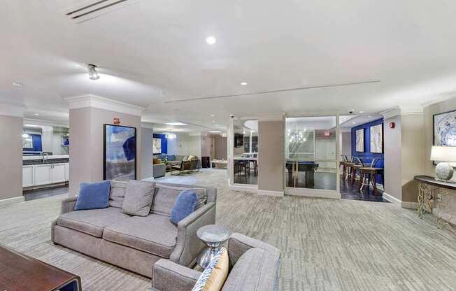 A spacious clubroom with a grey couch and a coffee table.