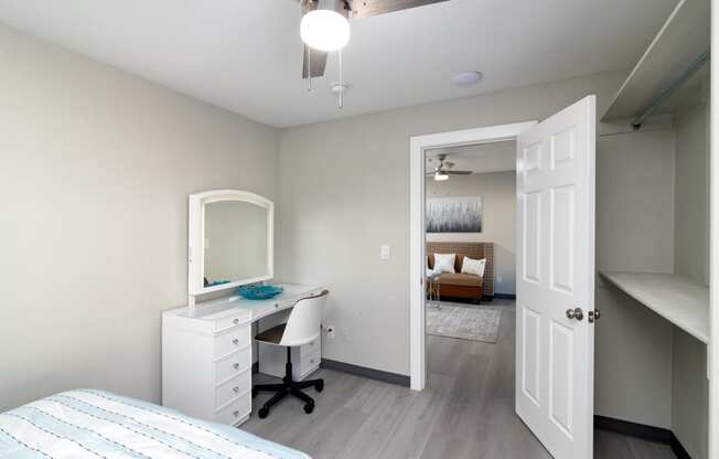a bedroom with a desk and a mirror