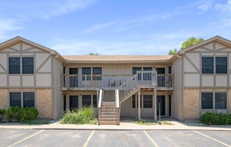 the exterior of an apartment building with stairs and a balcony