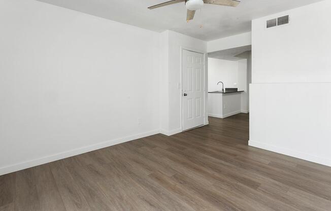 A room with a ceiling fan and a door.